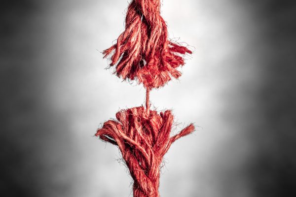 Frayed,Red,Rope,Hanging,By,Last,Thread,On,Black,And